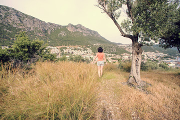 Woman on the hill looking over the city in the mountains