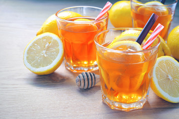 ice lemon tea with slice of fresh lemon in clear glass on wooden rustic background.