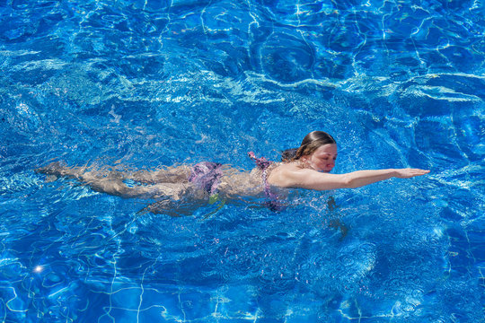 Woman in bikini swims in the pool