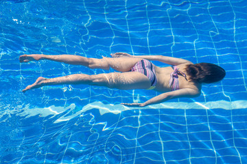 Woman in a bikini  swimming in the pool