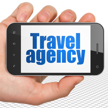 Vacation concept: Hand Holding Smartphone with Travel Agency on display