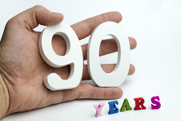 Hand holds a number ninety.