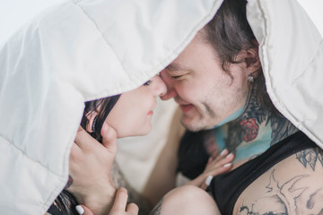 close-up couple girlfriend boyfriend cuddle, love, tattoo in bed white bed sheet under the blanket
