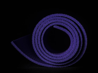 Healthy lifestyle background. Yoga mat on black background.