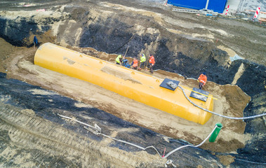Worker installing a huge fuel tank