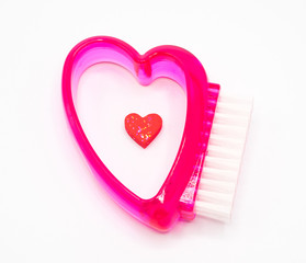 Red color heart shape handle cleaning brush on white background