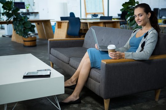 Portrait of a female business executive holding laptop