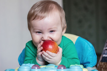 Fototapeta na wymiar baby eats red apple