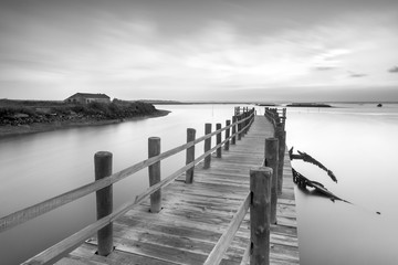 Ancient pier and abandoned boat at black and white fine art photography  - 136435664
