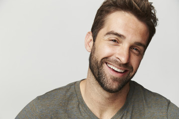 Happy guy in grey studio, portrait