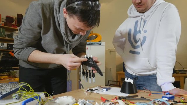 Engineers making robotic bionic arm made on 3D printer. 4K.