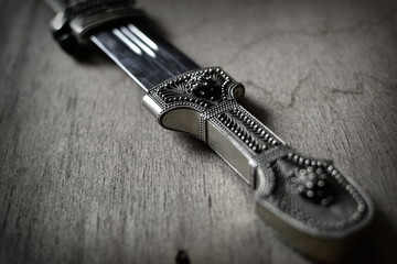 Ortiental style decoration dagger on weathered wood