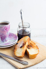 raspberry jam, toast and coffee on a white table