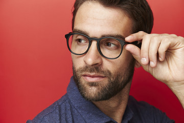 Fototapeta na wymiar Man adjusting glasses in studio, close up