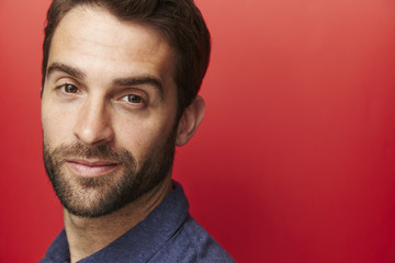 Obraz premium Smiling dude on red background, portrait