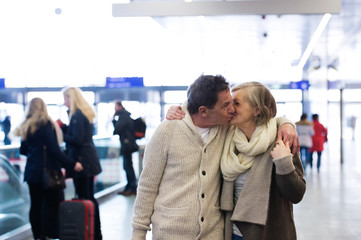 Senior couple standing in hallway of subway, kissing