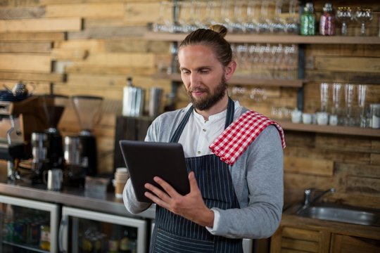 Waiter using digital tablet in café