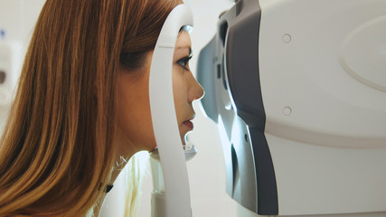 Female checks the eyes on the modern equipment in the medical center