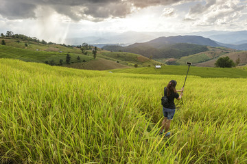 Fototapeta na wymiar girl do selfie herself in the rice field