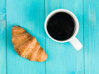 Mug of Black Coffee With A Single Breakfast Croissant