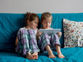 children sit on the couch, playing and watching cartoons  tablet 