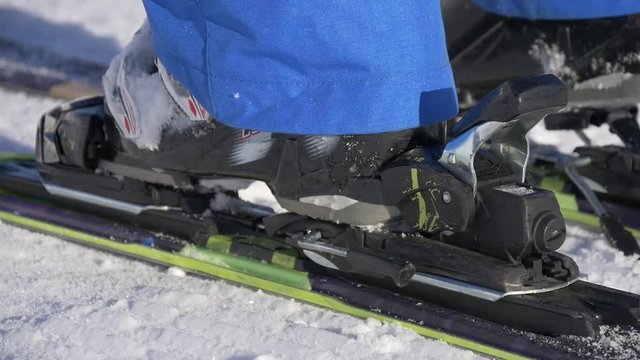 Woman puts boots to skis and rides away. Extreme close up