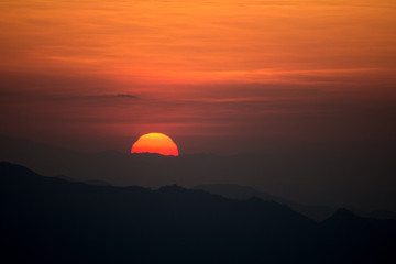 Fototapeta na wymiar Sunset at the Mountain Hill,Beautiful sunlight, Orange lights background
