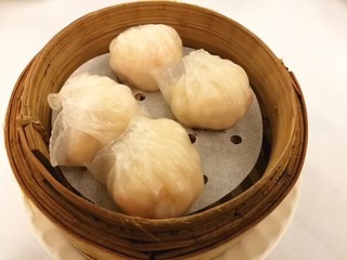 Steamed shrimp dumplings on bamboo basket, Ha gow, bamboo tray in the local tradional chinese food in China town with blur background table