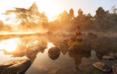 Beautiful Yoga woman in the morning at the hot spring park.