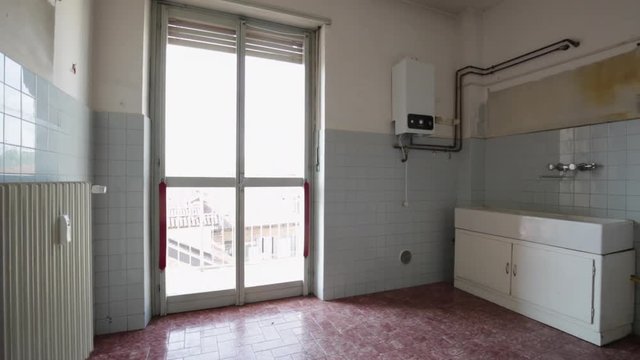Empty old kitchen with blue tiled walls