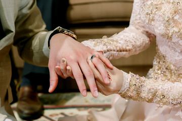 Hand of lover are wearing a ring on her wedding day