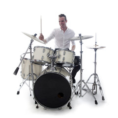 drummer behind drum set wears white shirt and plays the drums