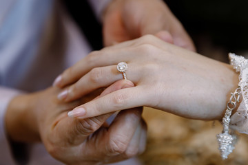 Hand of lover are wearing a ring on her wedding day