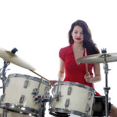 sexy brunette in red dress plays drum kit in studio