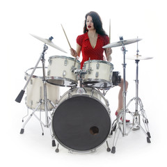 Fototapeta premium sexy brunette in red dress plays drum kit in studio