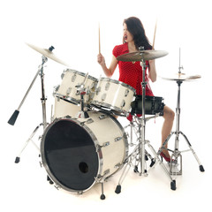 sexy brunette in red dress plays drum kit in studio