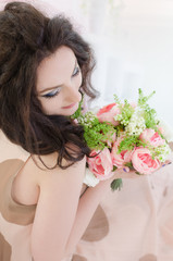 Top view of a beautiful girl in vintage beige dress with a wedding bouquet in hands