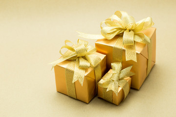 Gold gift box on brown paper background