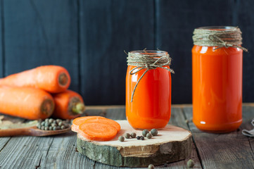 Two glass jars with fresh carrot juice