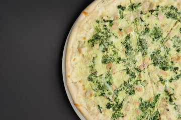 Top view of part of pizza with ham and mushroom on black background
