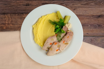 Top view of cold boiled pork with potato puree and pickled cucum