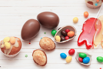 Chocolate Easter Eggs and Cupcake Over Wooden Background