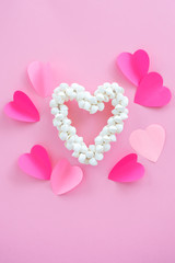 wreath of white shells in the shape of a heart red background of the paper. Still minimalist concept of love, feelings, happiness