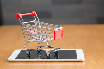 Tablet and shopping cart on wood table, Online shopping concept