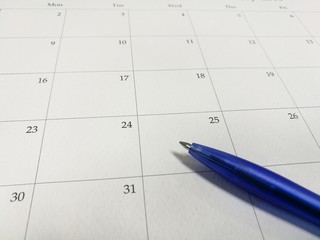 Blue ball pen on the calendar, calendar backgroud, focus-on foreground