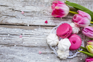 French macaroons delicious cookies and pink tulips for Valentine's Day. Space for text.