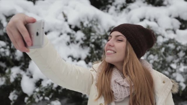 Girl in the snowy forest makes a selfie
