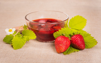 Fresh red strawberry and jam on textile background