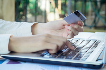 Woman's hands holding a credit card and using smart phone for on