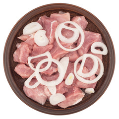 Raw meat chopped into pieces with onions in a brown plate.Isolat